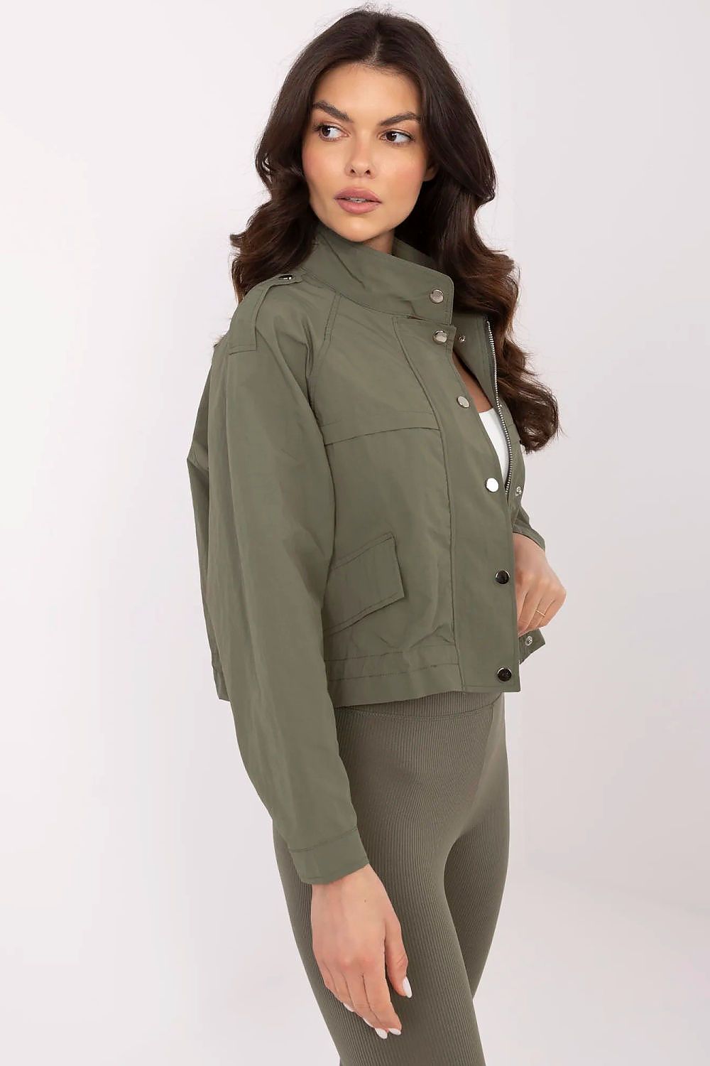 Woman wearing Corvaline lightweight windbreaker jacket in olive green, featuring a full-length zipper and snap-button placket.