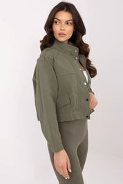 Woman wearing Corvaline lightweight windbreaker jacket in olive green, featuring a full-length zipper and snap-button placket.
