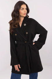 Woman wearing Selvarinne double-breasted short coat with waist tie and decorative brooch, showcasing a structured silhouette.