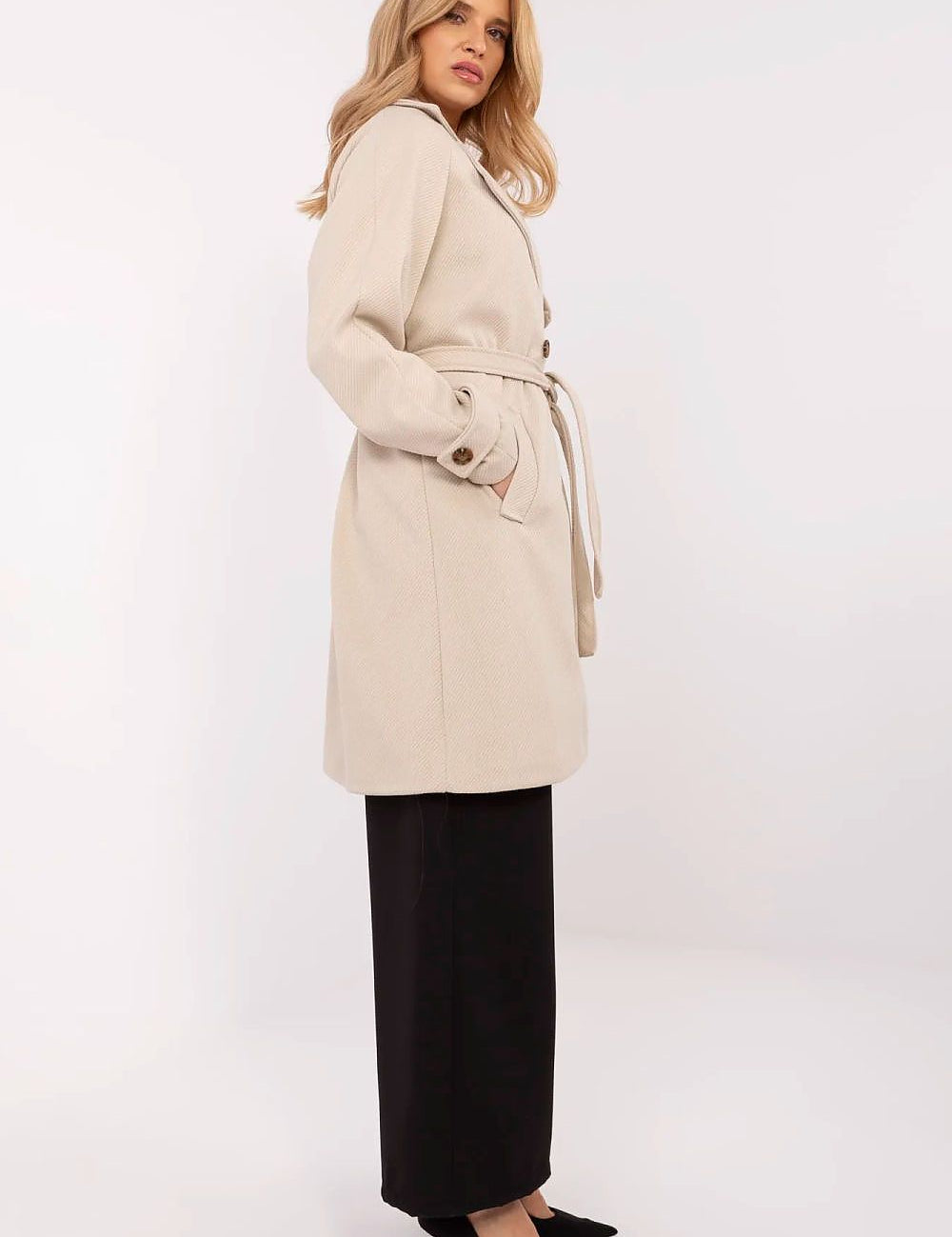 Woman wearing Corvanne Double-Breasted Belted Coat, knee-length, beige, with subtle stripes, side view, perfect for transitional seasons.