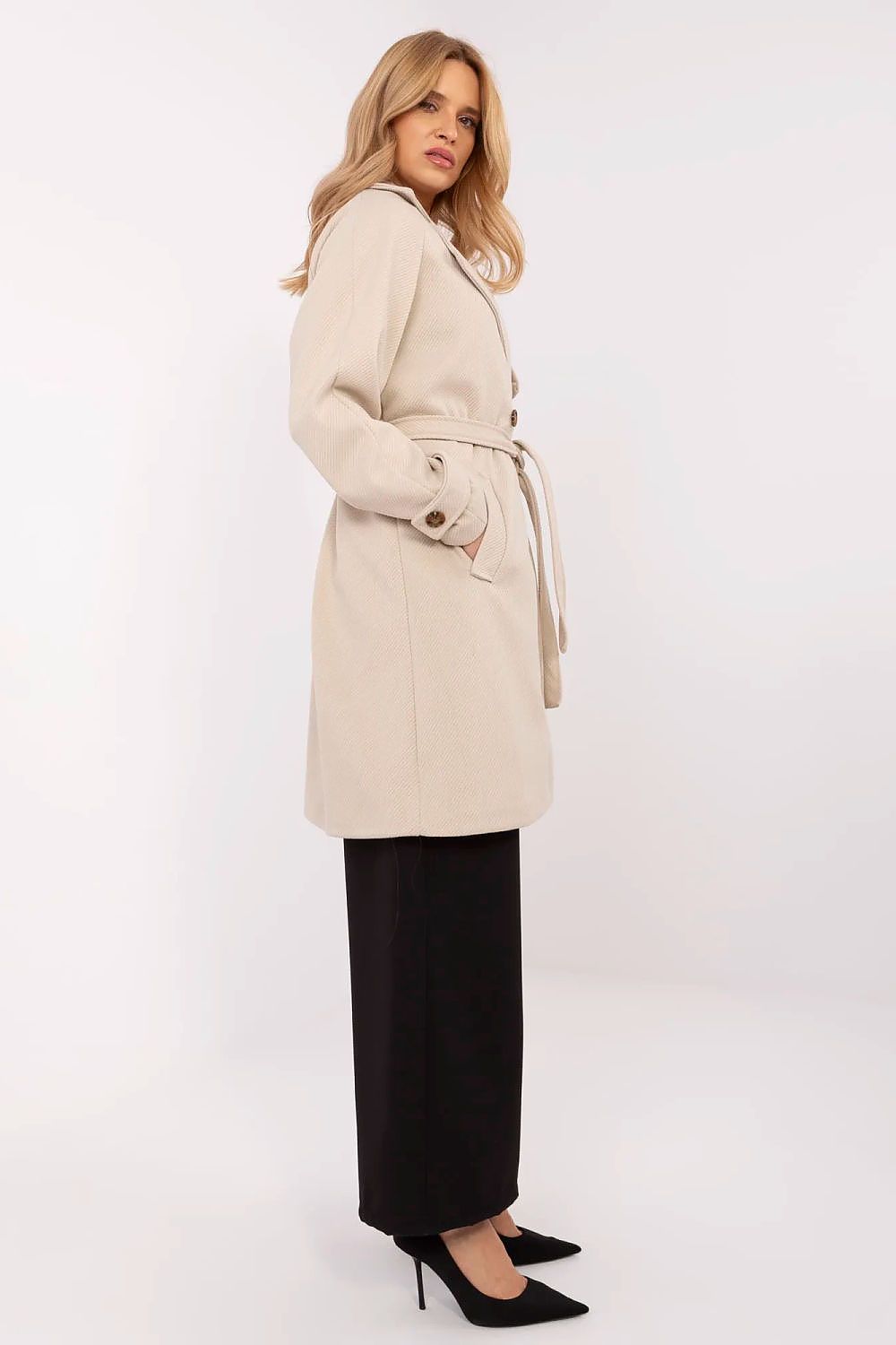 Woman wearing Corvanne Double-Breasted Belted Coat, knee-length, beige, with subtle stripes, side view, perfect for transitional seasons.