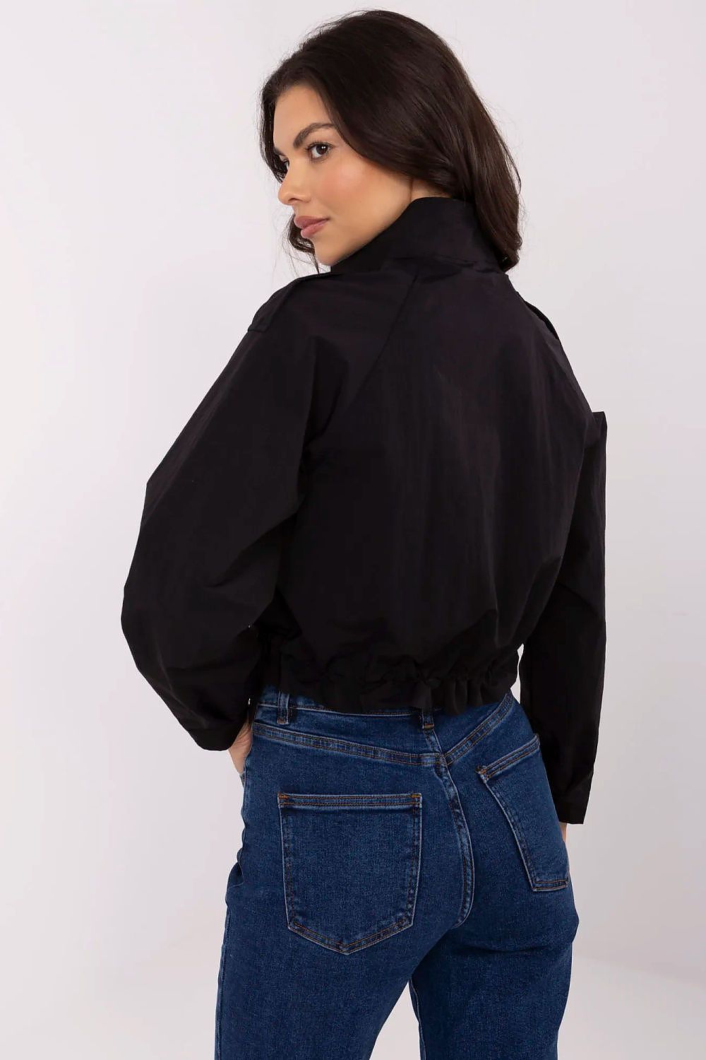 Woman wearing Corvaline lightweight windbreaker jacket in black, rear view showcasing the stylish fit and durable polyester fabric.