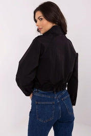 Woman wearing Corvaline lightweight windbreaker jacket in black, rear view showcasing the stylish fit and durable polyester fabric.