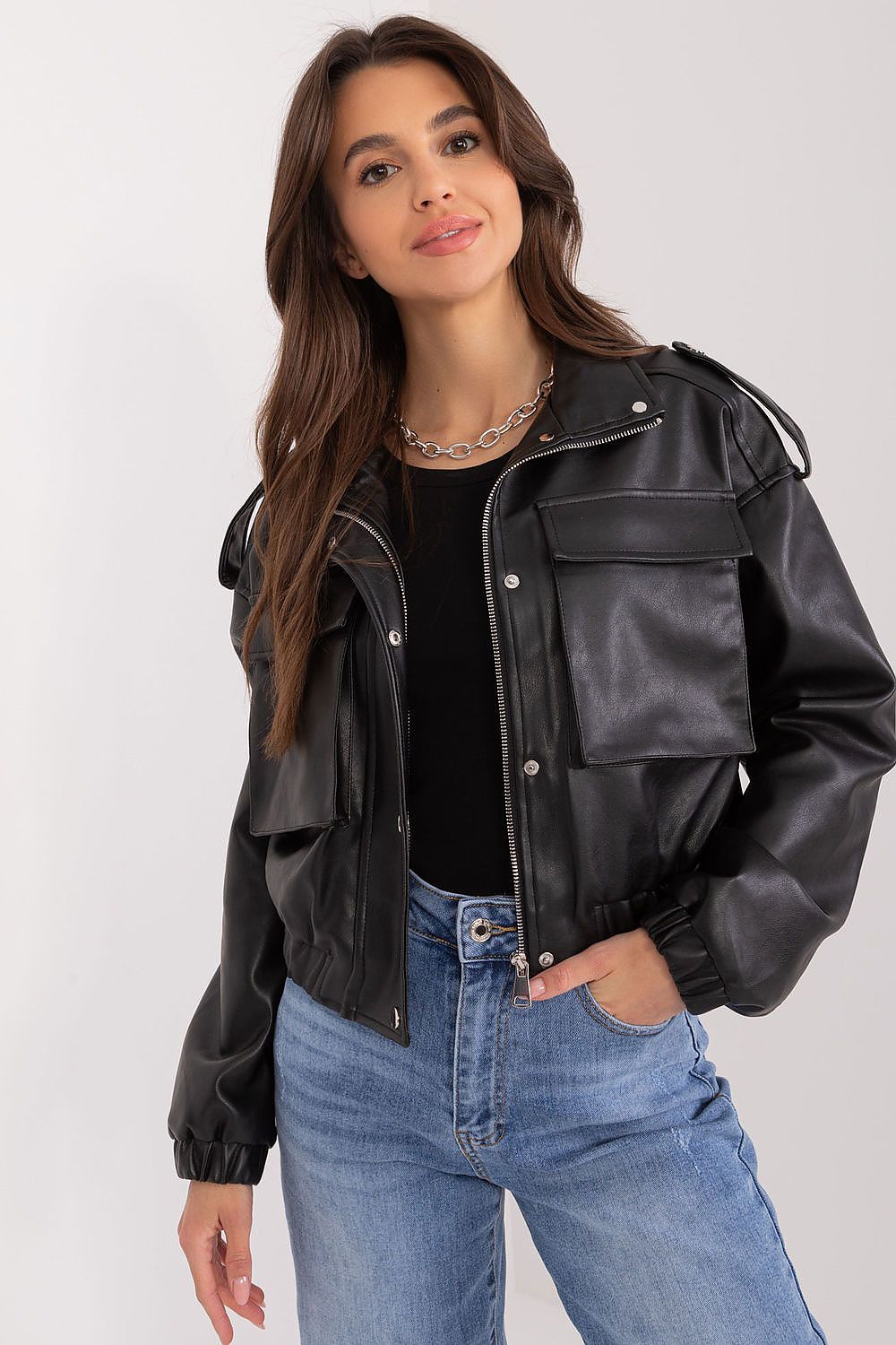 Woman wearing Arvenique Eco-Leather Short Jacket with front flap pockets and shoulder epaulettes, styled casually with jeans.