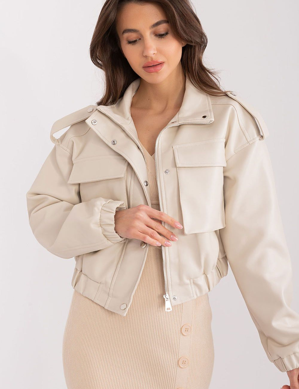 Woman wearing Arvenique eco-leather short jacket with long sleeves, zip closure, and front flap pockets, showcasing casual elegance.