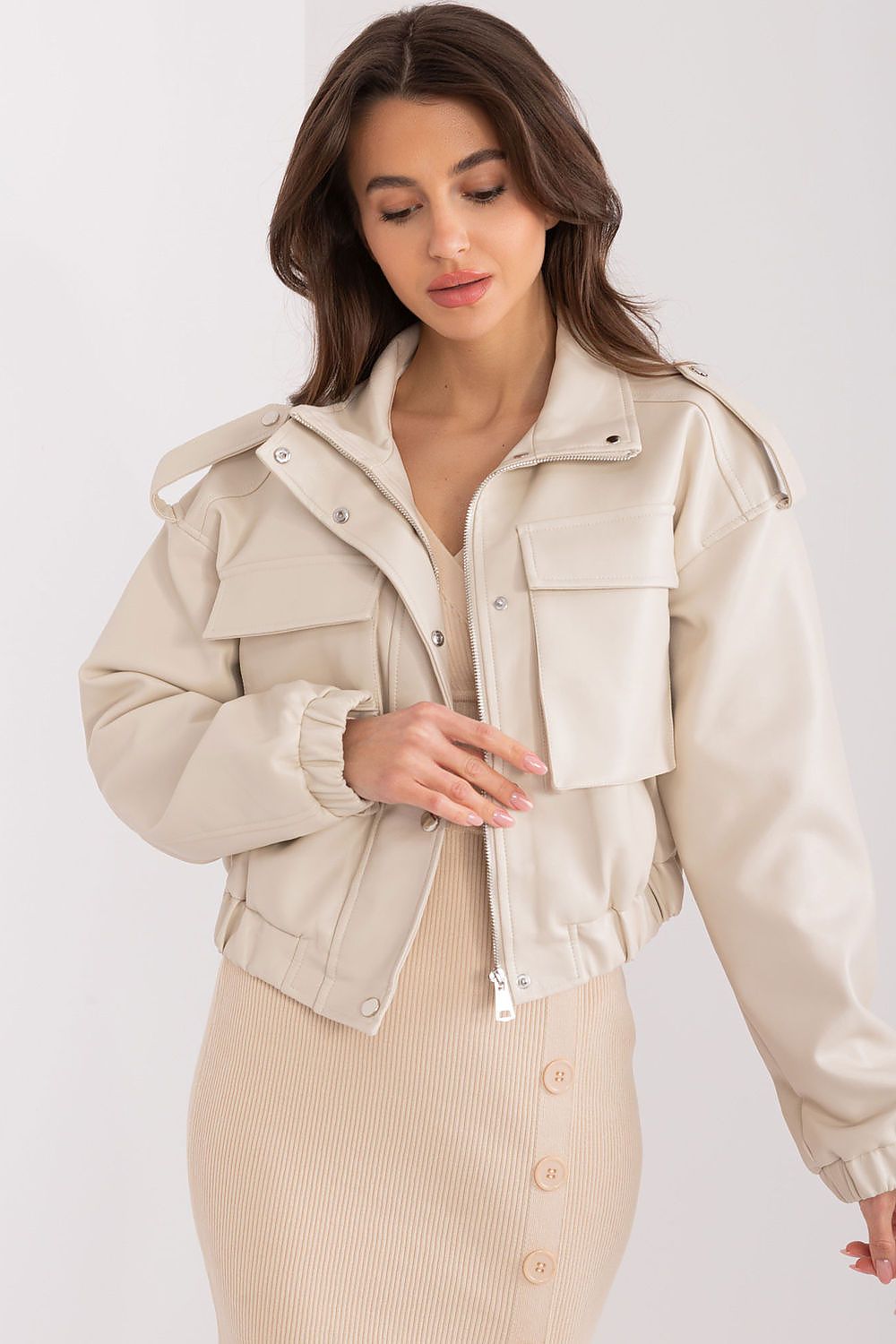 Woman wearing Arvenique eco-leather short jacket with long sleeves, zip closure, and front flap pockets, showcasing casual elegance.