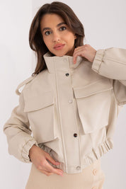 Woman wearing Arvenique eco-leather short jacket with large flap pockets and shoulder epaulettes, showcasing casual elegance.