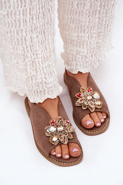 Fiorenna Flat Suede Flower Sandals with sculpted flower accent and cushioned insole for comfort, styled with white textured pants.