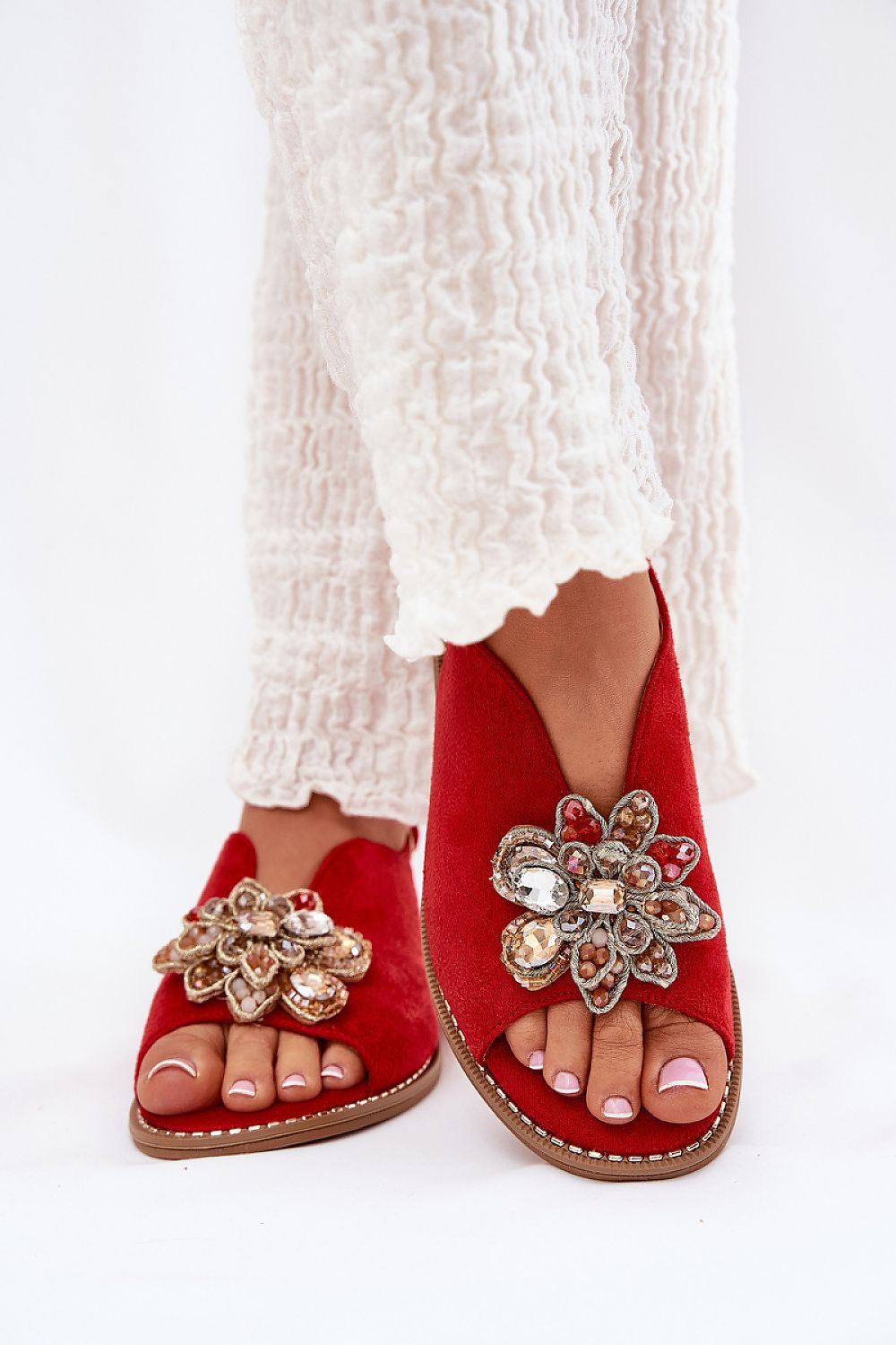 Red Fiorenna suede flower sandals with decorative accents and cushioned insoles, featuring an adjustable ankle strap for comfort.