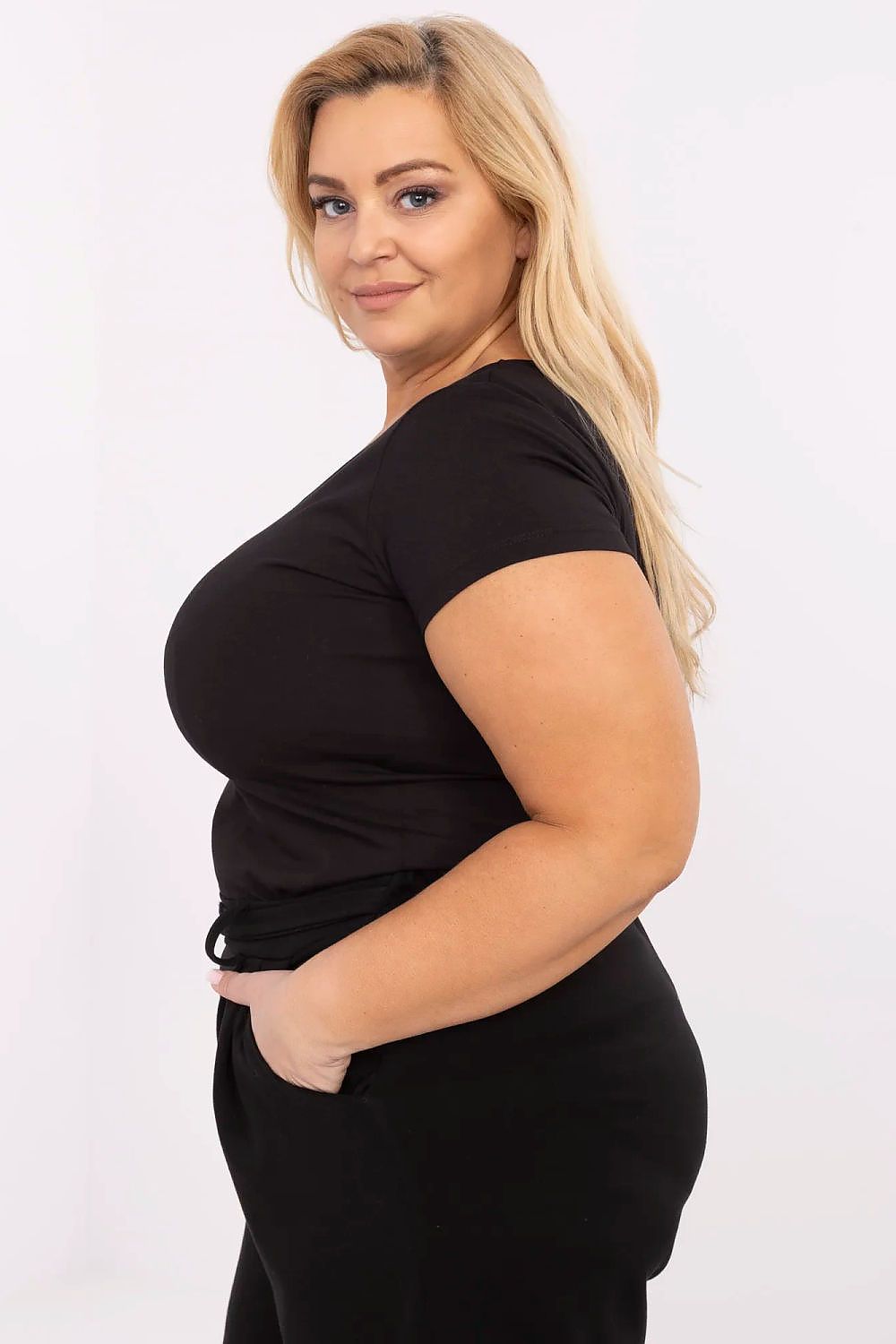 Woman wearing Elvarra Plus Size Cotton Tee in black, showcasing short sleeves and round neckline, perfect for casual style.