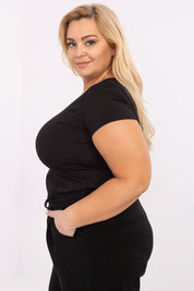 Woman wearing Elvarra Plus Size Cotton Tee in black, showcasing short sleeves and round neckline, perfect for casual style.