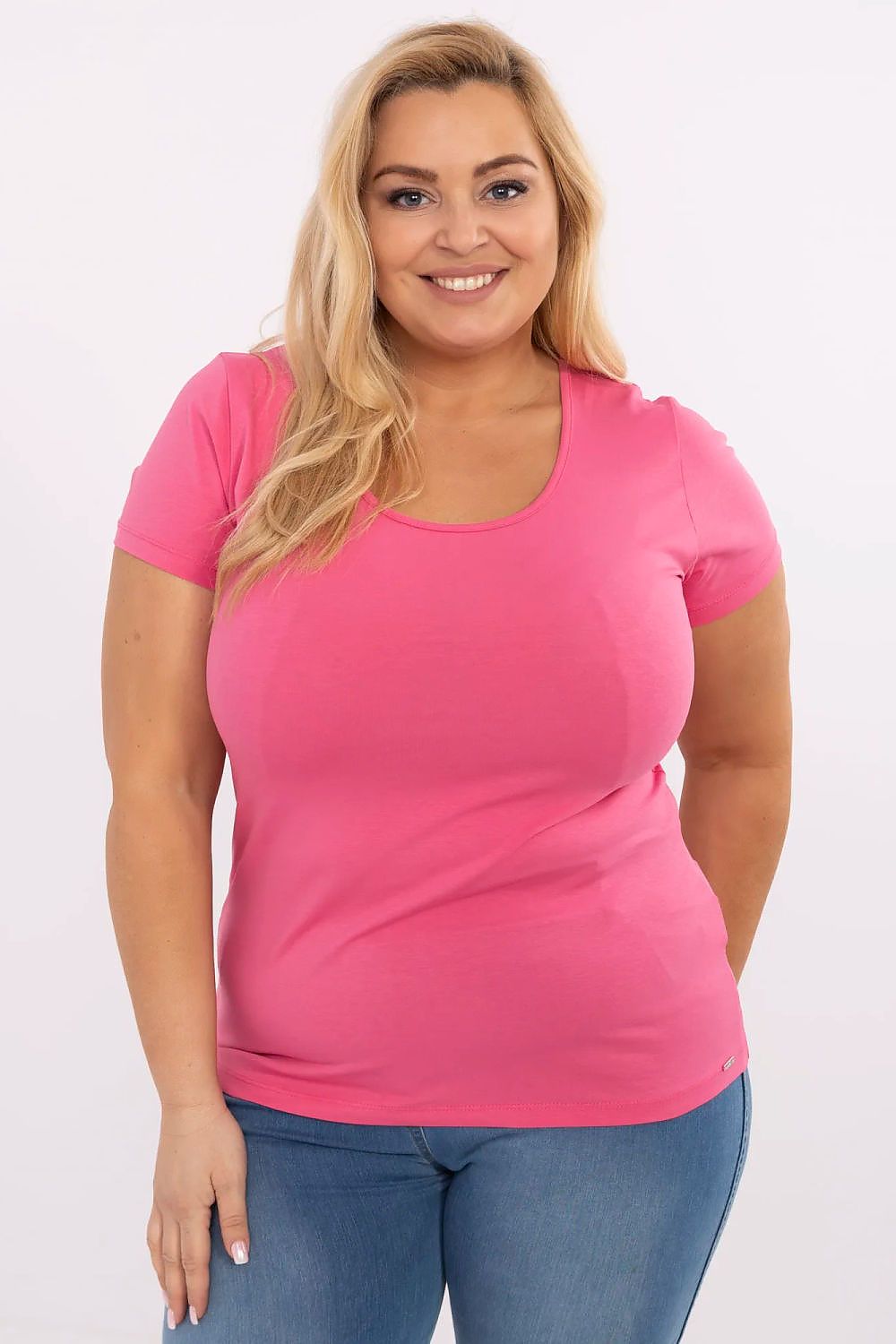 Woman wearing Elvarra Plus Size Cotton Tee in pink, featuring short sleeves and round neckline for everyday style.