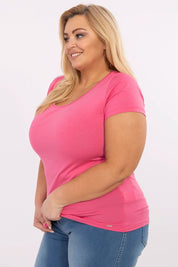 Woman wearing Elvarra Plus Size Cotton Tee in pink, showcasing short sleeves and a round neckline for comfortable daily style.