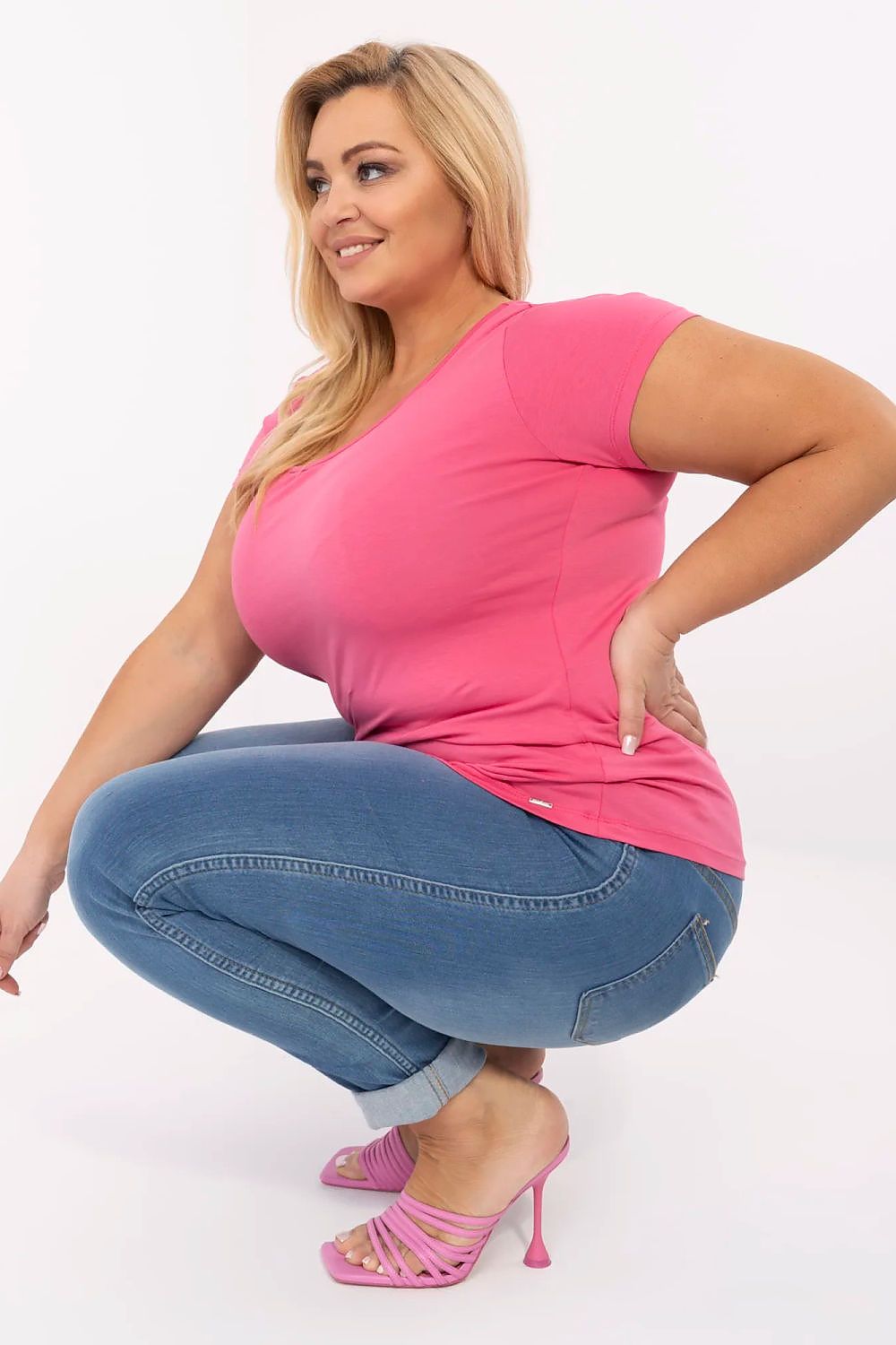 Model wearing Elvarra Plus Size Cotton Tee in pink with jeans and pink heels, showcasing style versatility and comfortable fit.