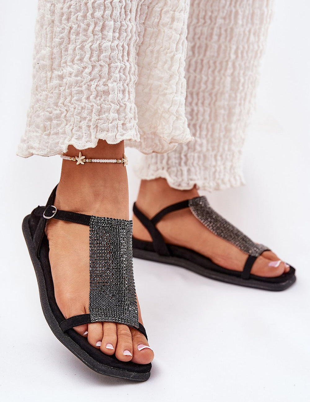 Black Alvarisse crystal strap flat sandals with adjustable ankle buckle and soft eco-leather insole, perfect for summer soirées.
