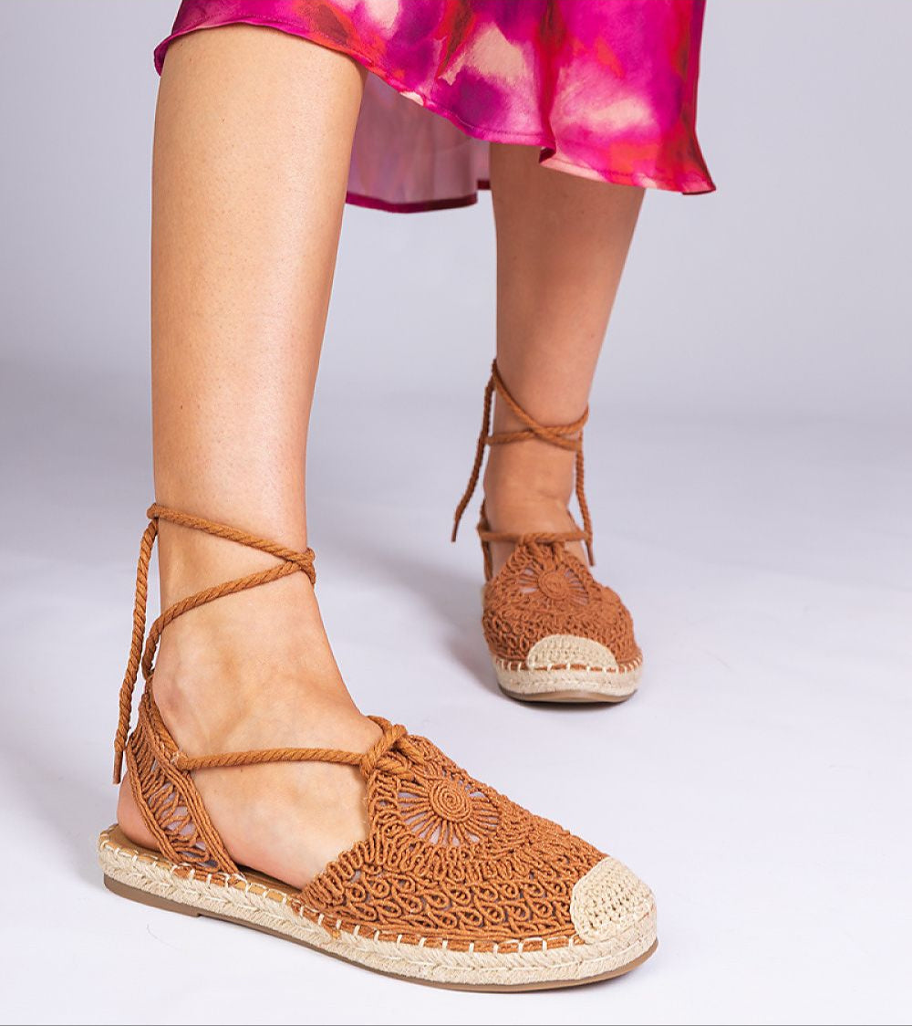 Woman wearing Serella Espadrille Sandals with braided sole and floral skirt, showcasing open design and fabric texture for summer style.
