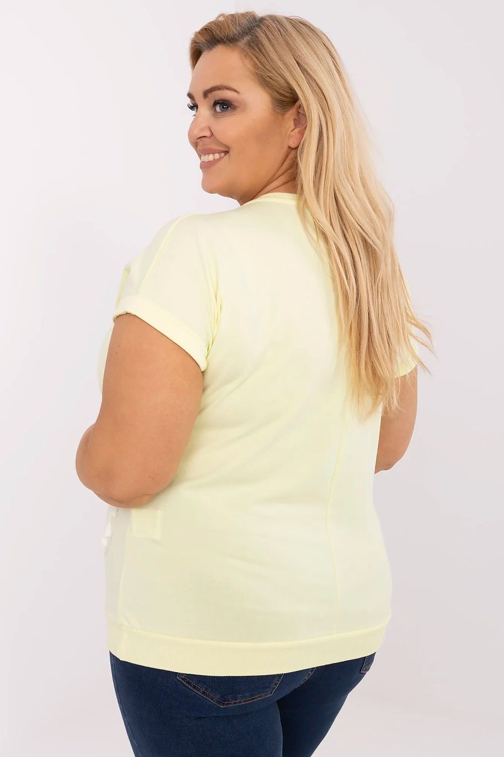 Back view of a plus-size model wearing a yellow stretch cotton blouse with short sleeves, highlighting the Melaria blouse's comfortable fit.