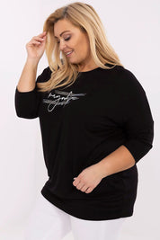 Plus size woman wearing Lioraelle printed jet blouse with 3/4 sleeves and round neckline, featuring sparkly inscription details.