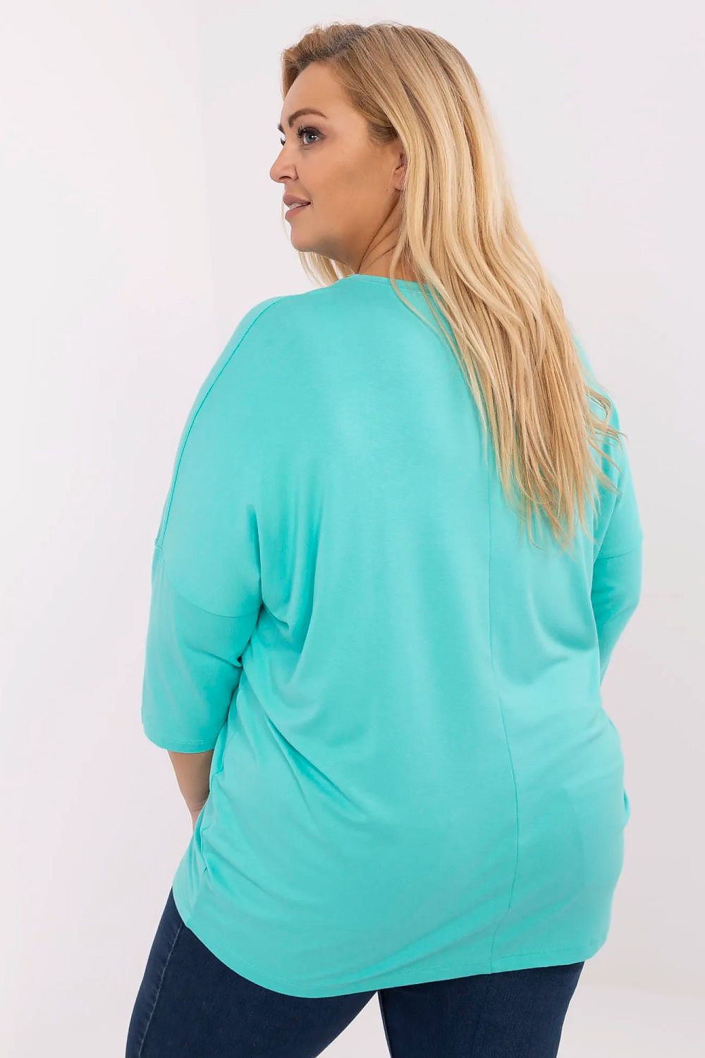 Back view of a woman wearing a turquoise plus size blouse with 3/4 sleeves, showcasing the drape and stretch of the fabric.