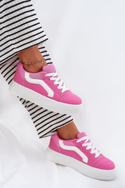 Pink Ravelin suede platform sneakers with white sole, paired with striped trousers, showcasing casual chic style and comfort.