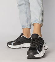 Thareen Platform Trainers in black with faux leather and chunky sole, worn with light jeans for an urban look.