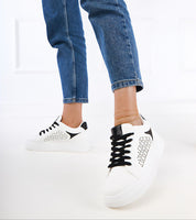 Person wearing Alnora Urban Platform Sneakers with blue jeans, showcasing durable eco leather and subtle blue accents for city life.