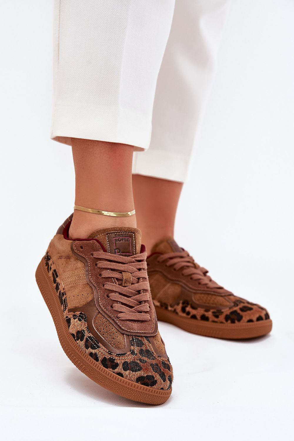 Brown suede sneakers with leopard print and white pants