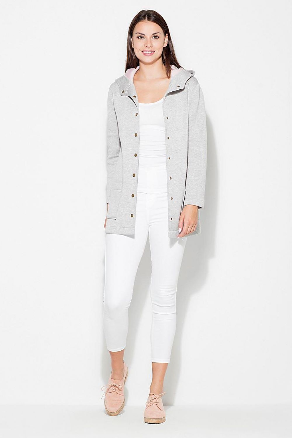 Woman wearing Katrienne Hooded Snap-Front Jacket in grey with decorative press studs, paired with white pants, showcasing a casual outfit.