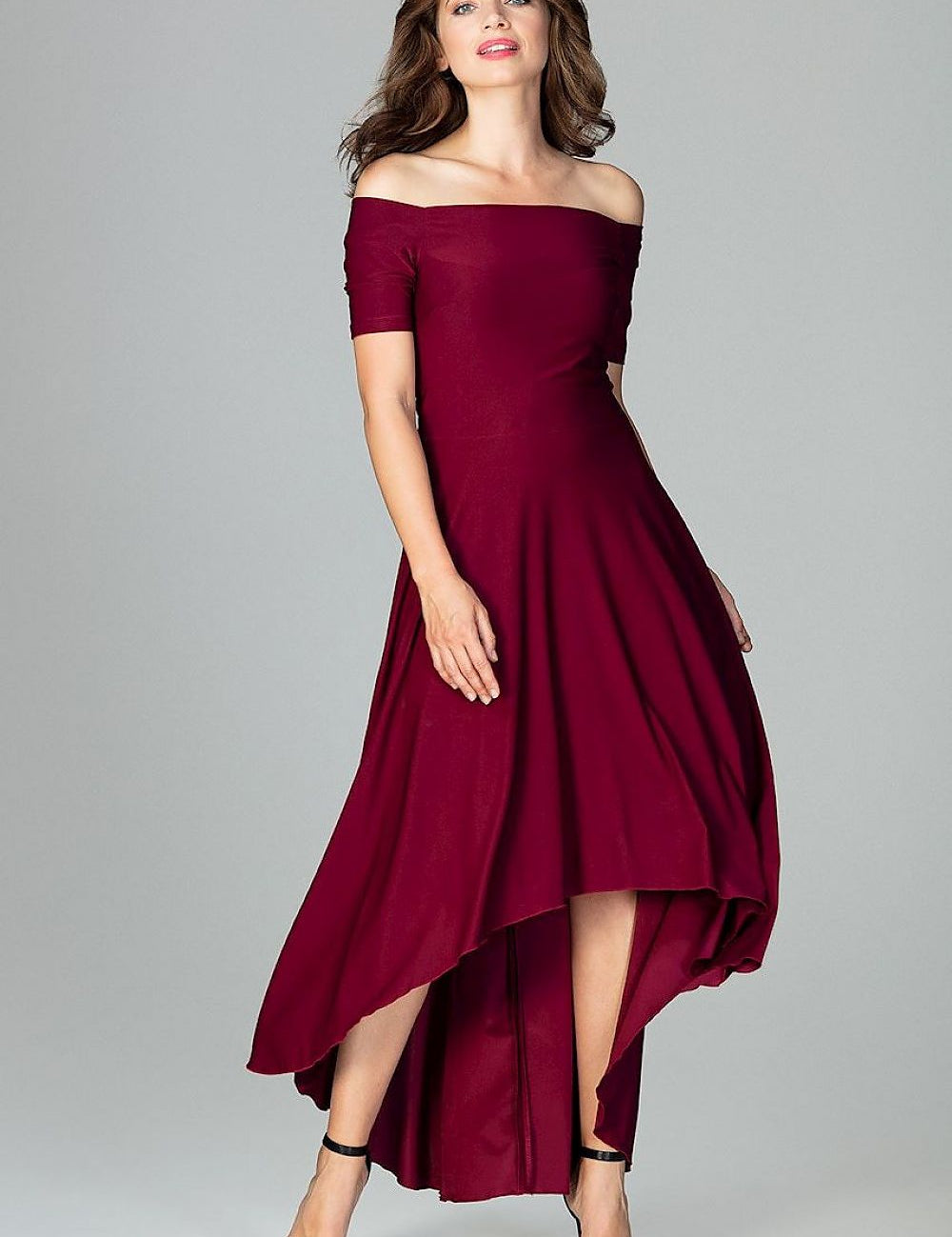 Woman modeling an off-shoulder burgundy cocktail dress with an asymmetrical hem, perfect for evening events and elegant occasions.