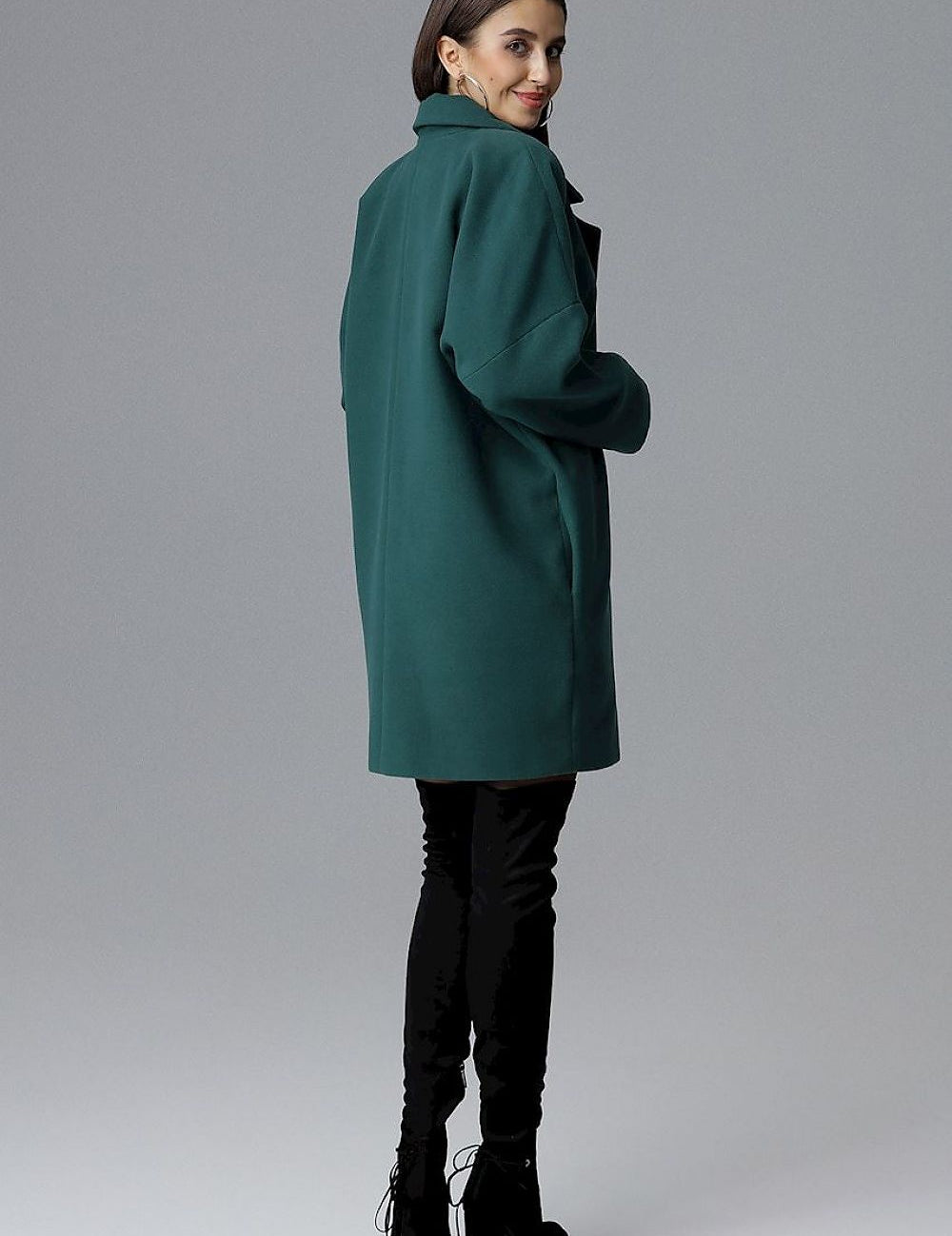 Woman wearing Calverra loose-fit coat with kimono sleeves, green color, double-breasted design, stylish and versatile for all occasions.