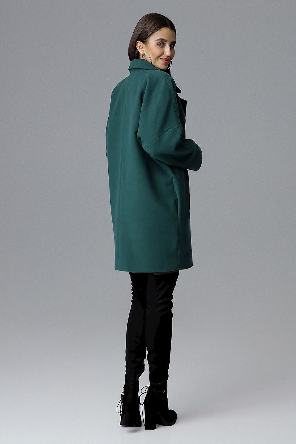Woman wearing Calverra loose-fit coat with kimono sleeves, green color, double-breasted design, stylish and versatile for all occasions.