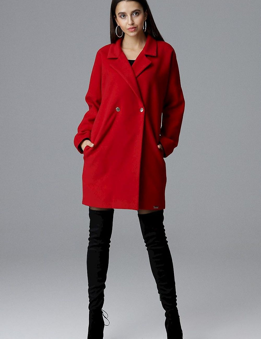 Model wearing Calverra loose-fit coat with kimono sleeves in red, showcasing its double-breasted design and elegant style.