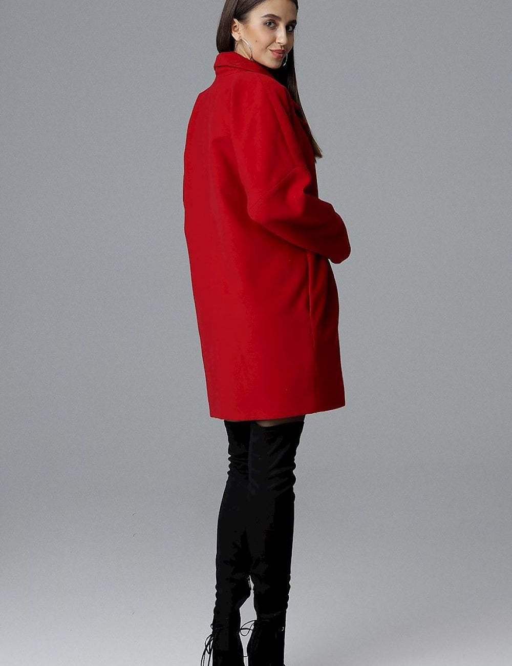 Model wearing red Calverra loose-fit coat with kimono sleeves, highlighting double-breasted design and elegant silhouette.