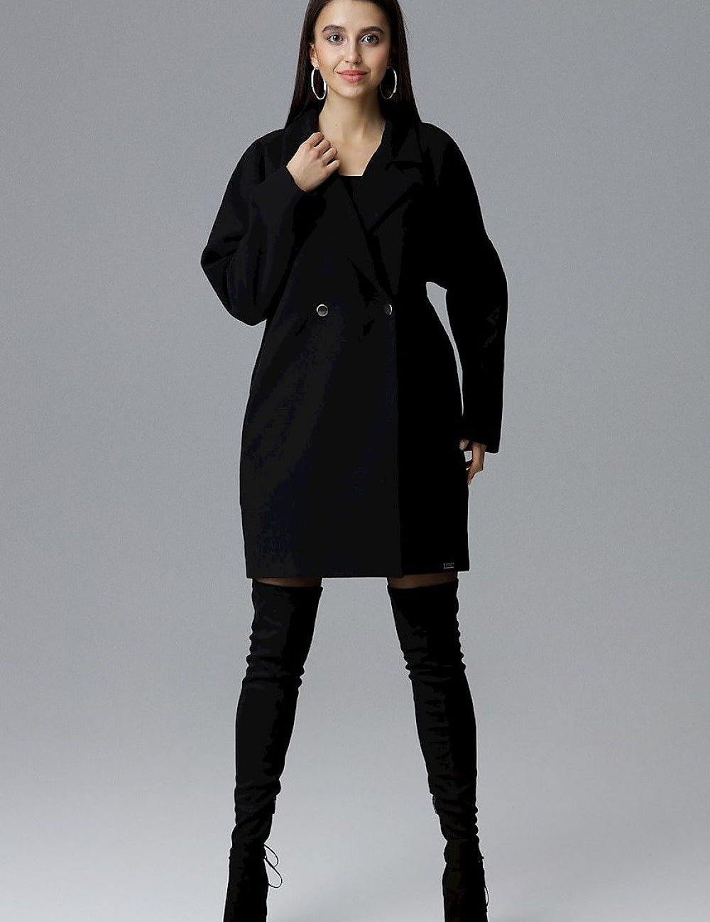 Model wearing Calverra loose-fit coat with kimono sleeves, double-breasted design, and decorative buttons; elegant and versatile fashion.