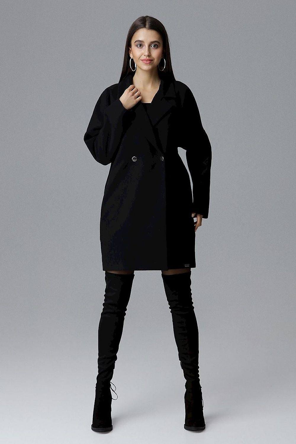 Model wearing Calverra loose-fit coat with kimono sleeves, double-breasted design, and decorative buttons; elegant and versatile fashion.