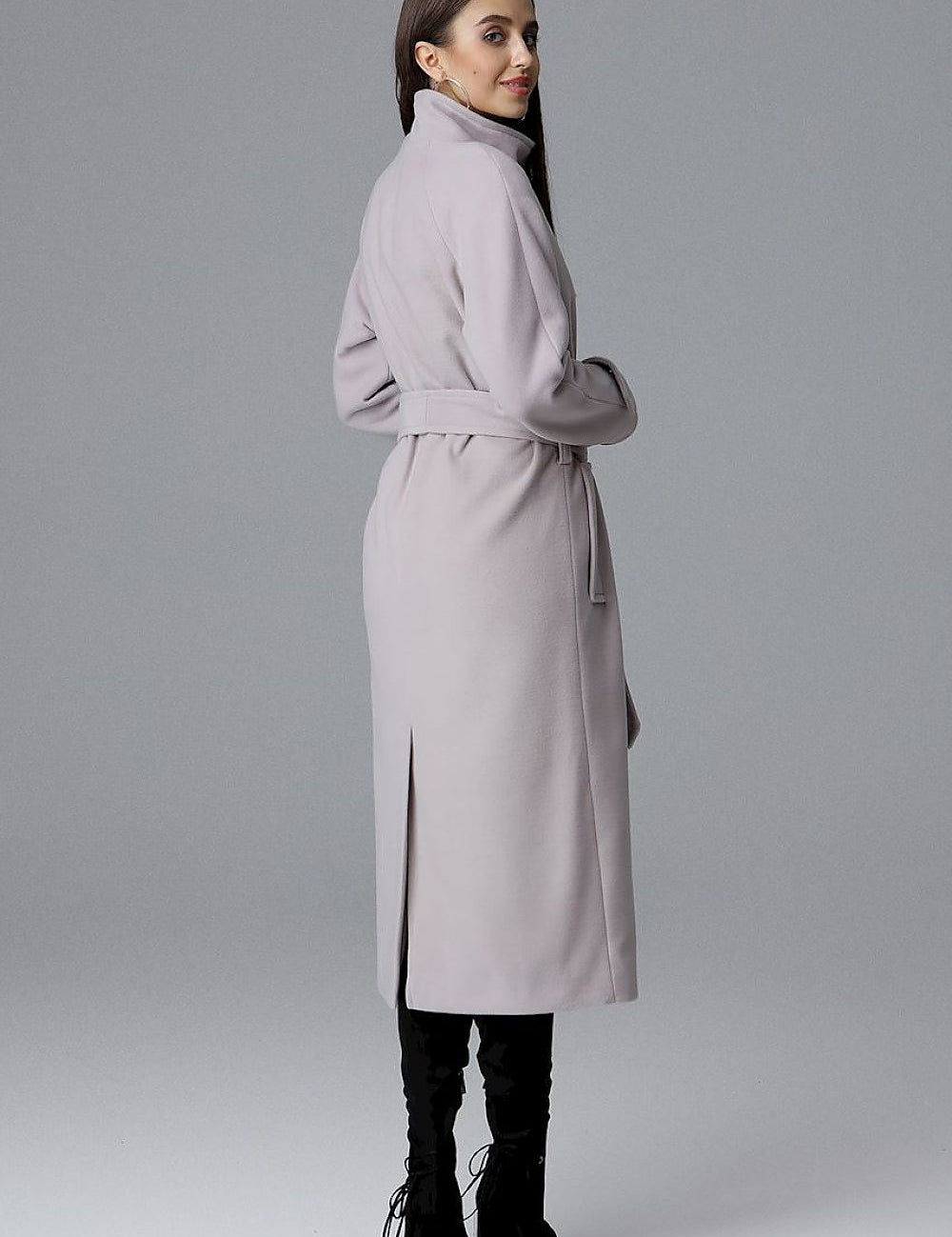 Woman wearing Melvarine long single-breasted belted coat with back slit, showcasing elegant and versatile design.