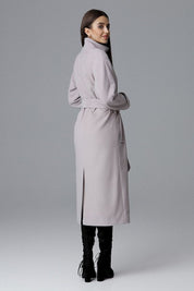 Woman wearing Melvarine long single-breasted belted coat with back slit, showcasing elegant and versatile design.