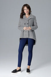 Woman wearing a houndstooth stand-collar jacket with modern zipper details, paired with blue leggings and black platform shoes.