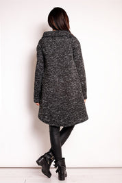 Back view of a woman wearing the Elvathine Loose-Fit Coat with an extended back hem, showcasing the coat's modern and relaxed silhouette.