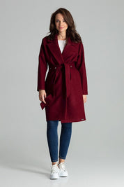 Woman wearing Carivelle Maroon Belted Coat with Wide Lapels, featuring metal eyelets and side-seam pockets, styled with jeans and sneakers.