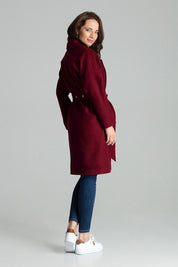 Woman wearing Carivelle maroon belted coat, wide lapels, side-seam pockets, metal eyelet belt, perfect blend of classic and elegant style.