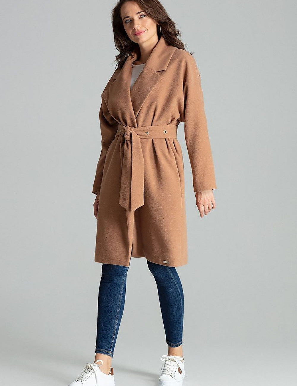 Model wearing a Carivelle maroon belted coat with wide lapels, featuring metal eyelets and side-seam pockets.