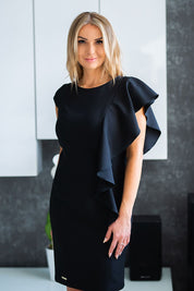 Woman wearing black Florentia ruffle evening dress with butterfly sleeves, showcases elegant plus-size fashion.