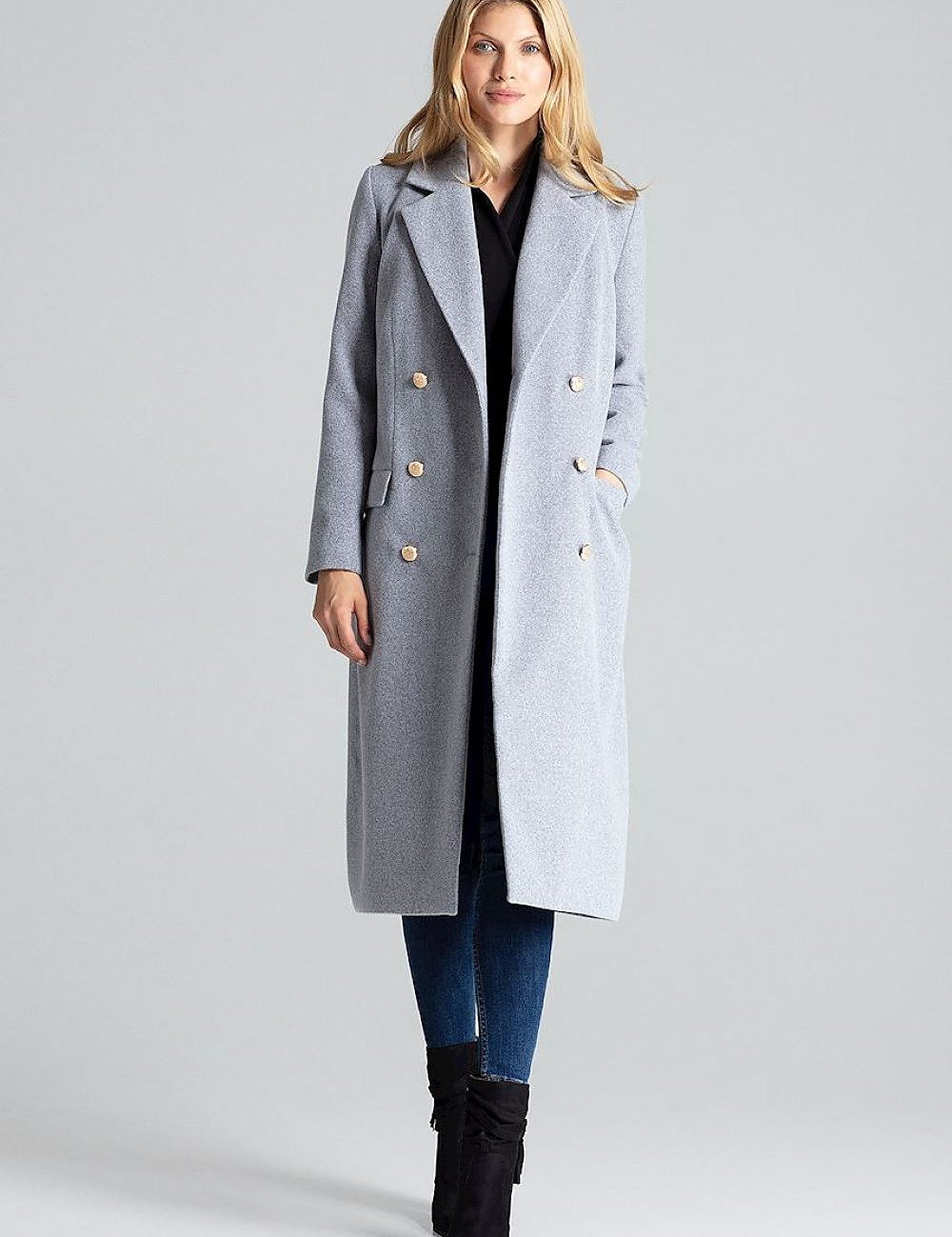 Woman wearing Vernadell gray double-breasted coat with gold buttons, tailored collar, and patch pockets. Elegant winter fashion.