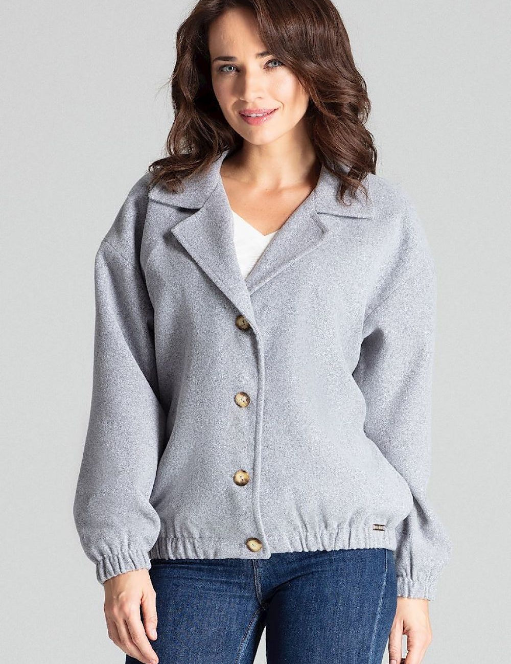 Woman wearing Cerythra Short Grey Loose-Fit Jacket with decorative buttons and elasticated cuffs for a relaxed silhouette.