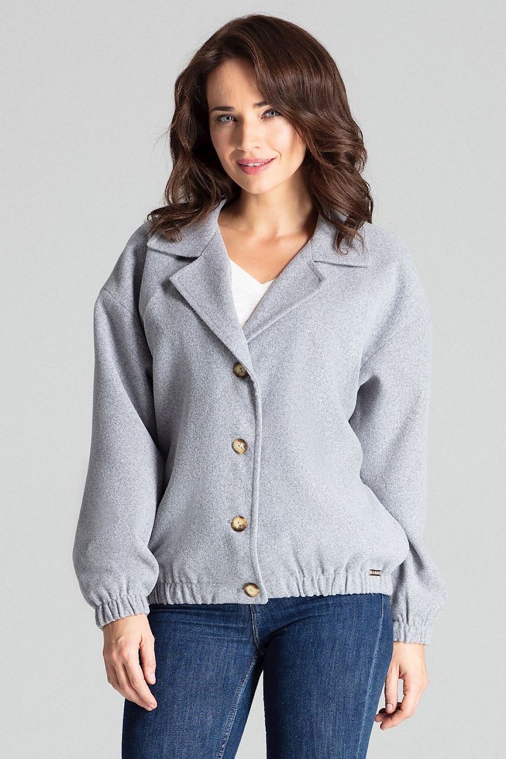 Woman wearing Cerythra Short Grey Loose-Fit Jacket with decorative buttons and elasticated cuffs for a relaxed silhouette.