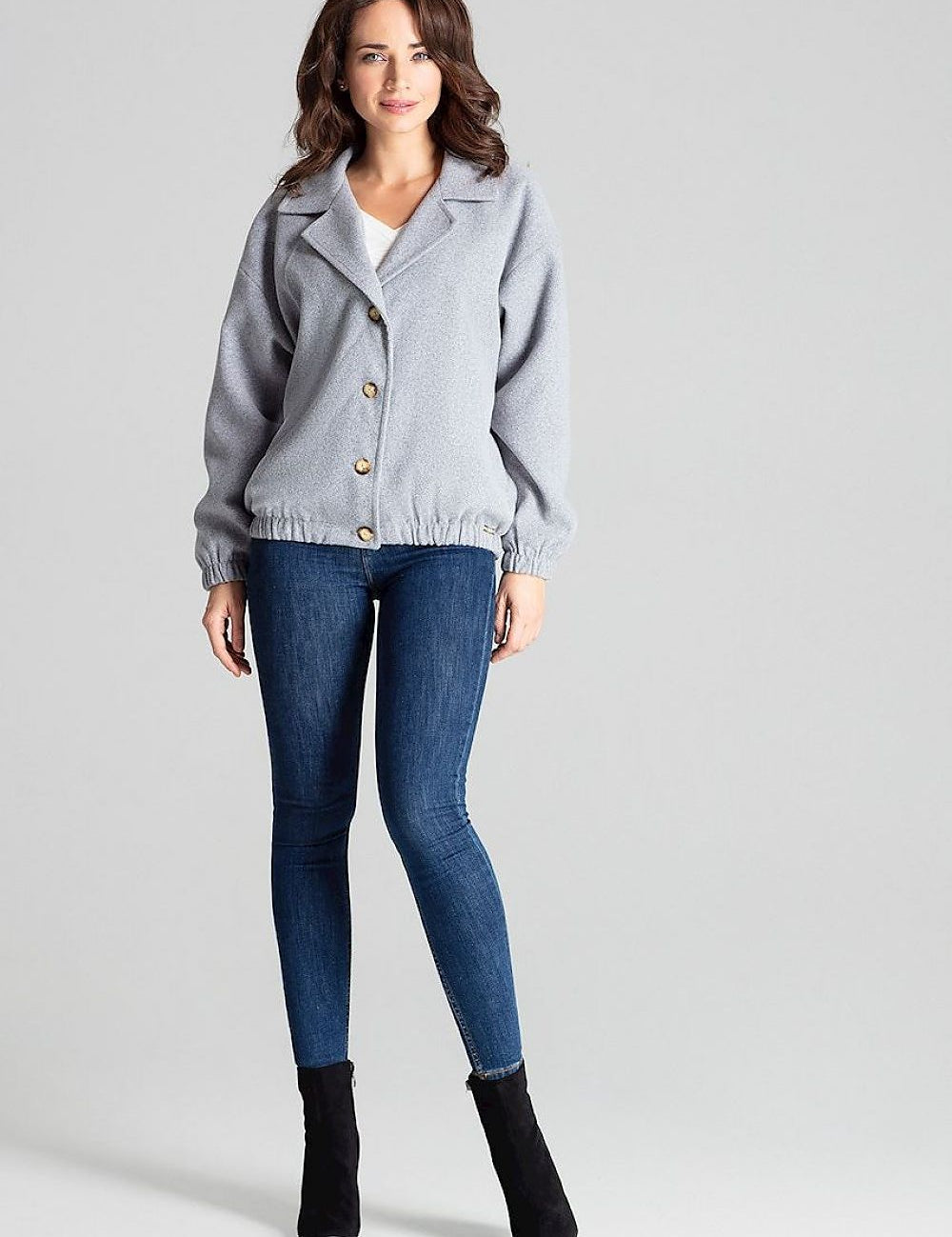 Model wearing Cerythra short grey loose-fit jacket with decorative buttons, dropped sleeves, and elasticated cuffs, styled casually.