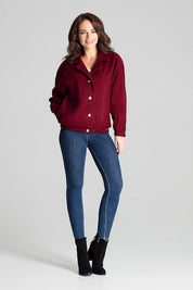 Woman wearing a short red loose-fit jacket with dropped sleeves, stylishly paired with jeans and ankle boots for a chic casual look.