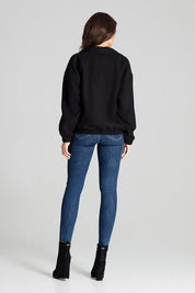 Back view of woman wearing blue jeans and black jacket with boots.