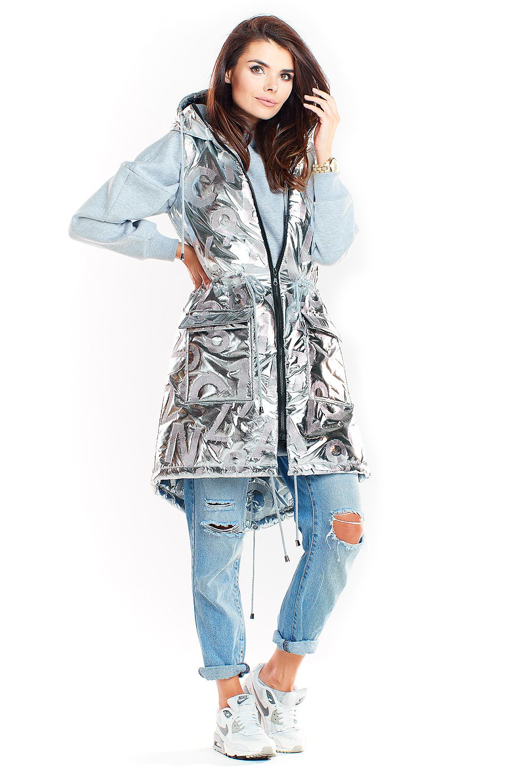 Woman wearing Orlavine Shiny Quilted Hooded Gilet Vest in black and silver, showcasing side pockets and extended back hem.